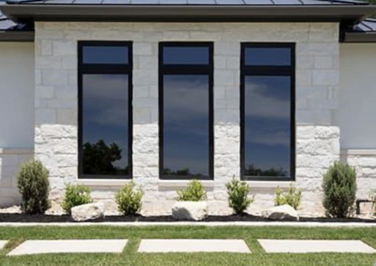 Black-framed impact windows on a Florida stone-and-stucco home